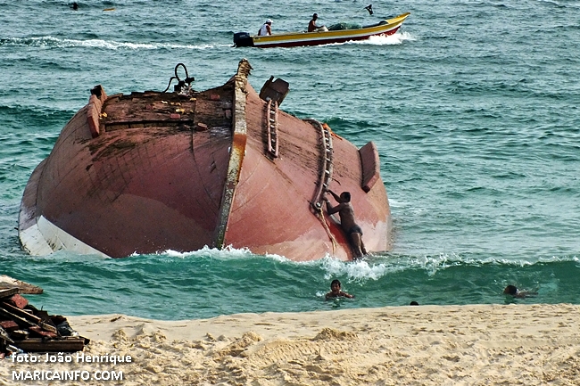 Banhistas desrespeitam isolamento e se arriscam subindo na embarcação naufragada. (fotos: João Henrique | Maricá Info)