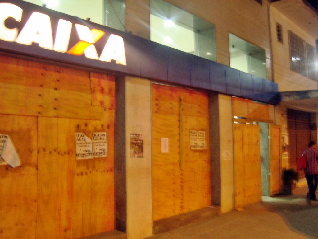 Tapumes de madeira protegem vidraças em agência da Caixa no Centro de Maricá. (Foto: João Henrique | Maricá Info)