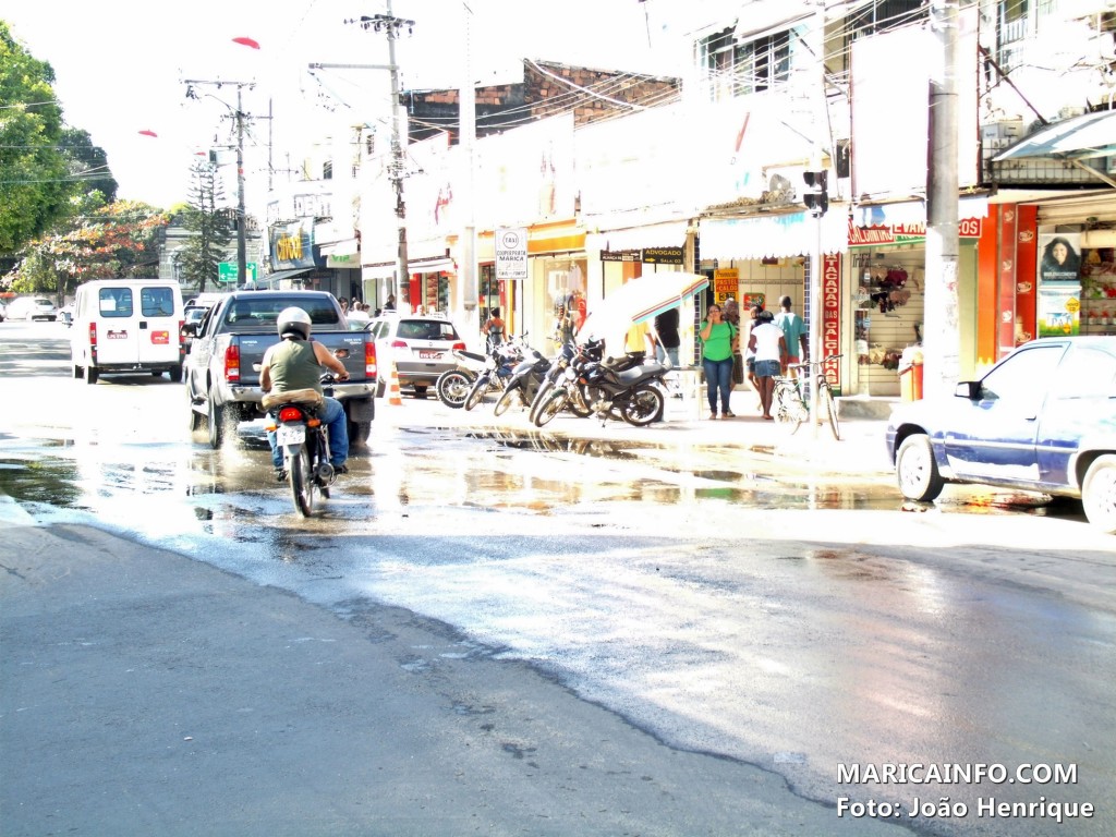 Carros, motos e pedestres em meio ao esgoto no Centro da cidade. (Foto: João Henrique | Maricá Info)