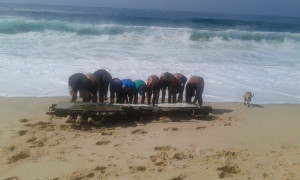 Alunos de escolinha de surf da rua 4, na Barra de Maricá, encontraram o pedaço de madeira que seria da embarcação Sinal da Cruz. (foto: Bruna Vaz)