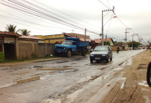 Carro desvia de buracos na Avenida Van Lerberque (Antiga Avenida 2). (foto: João Henrique / Maricá Info)