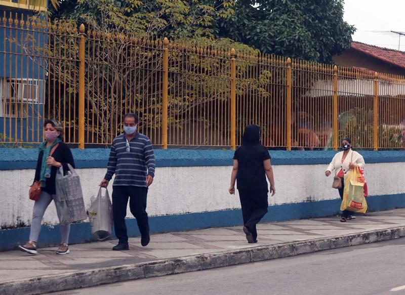 Pessoas andando no Centro com máscara